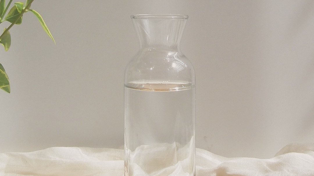 A glass water carafe on a pale surface